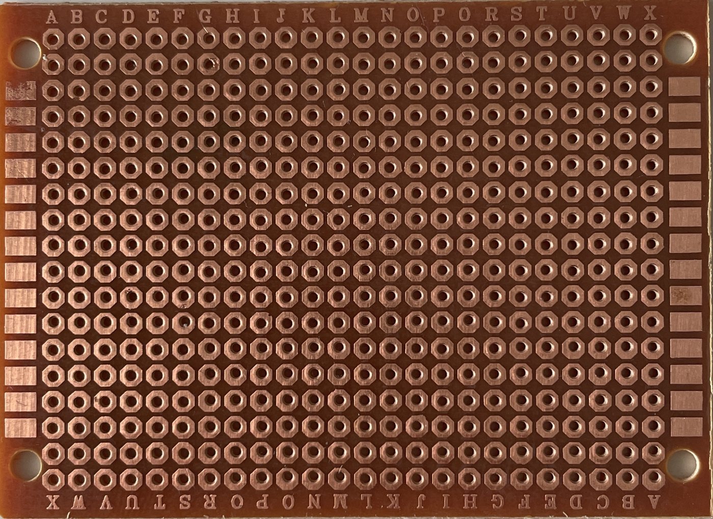 Photograph of the same prototype panel from the copper side, showing one copper strip per row of holes.